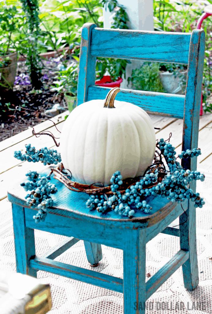 cute white pumpkin on vintage turquoise student chair