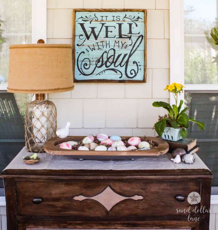 dresser on porch decorated for spring