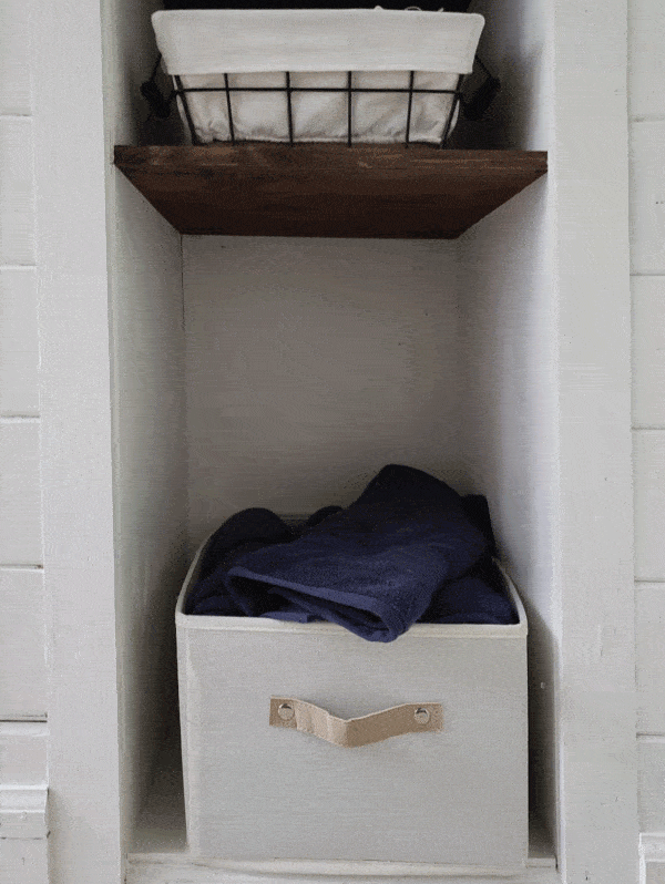 navy blue towels in white bin