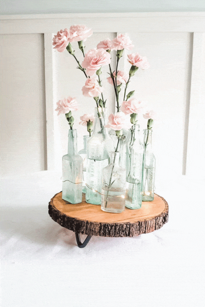 spring centerpiece for table with vintage medicine bottles and pink carnations