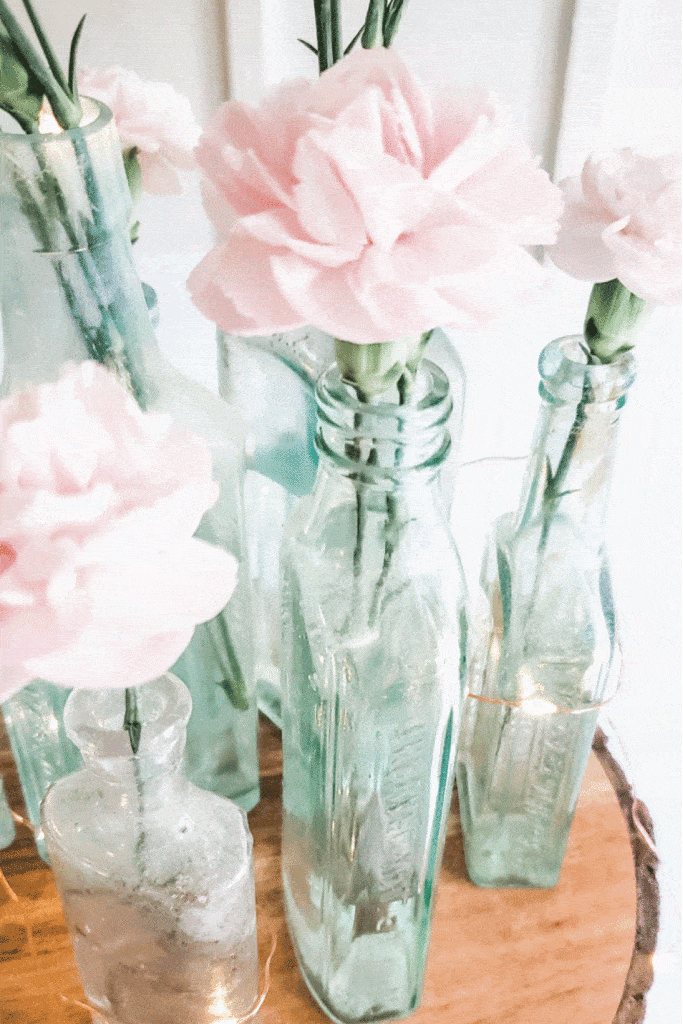 pink carnations in old medicine bottles