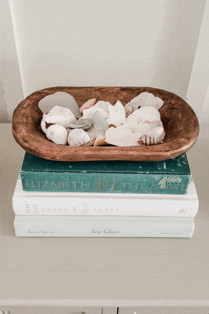 wooden dough bowl with seashells on entryway table