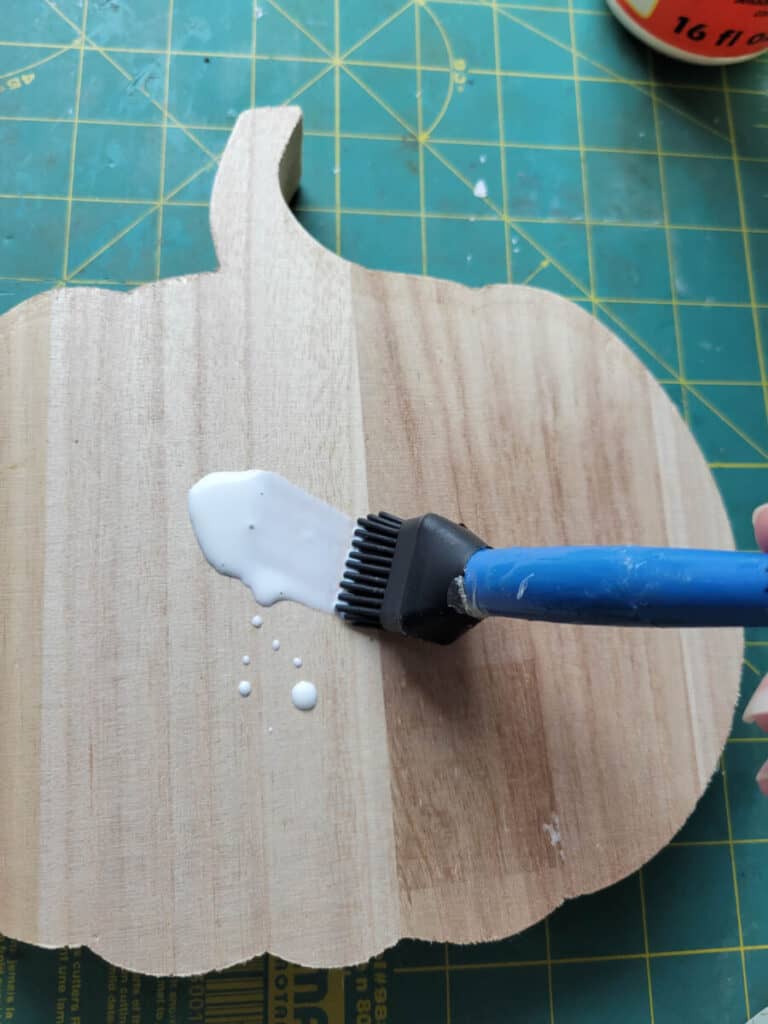 adding glue to wooden pumpkin