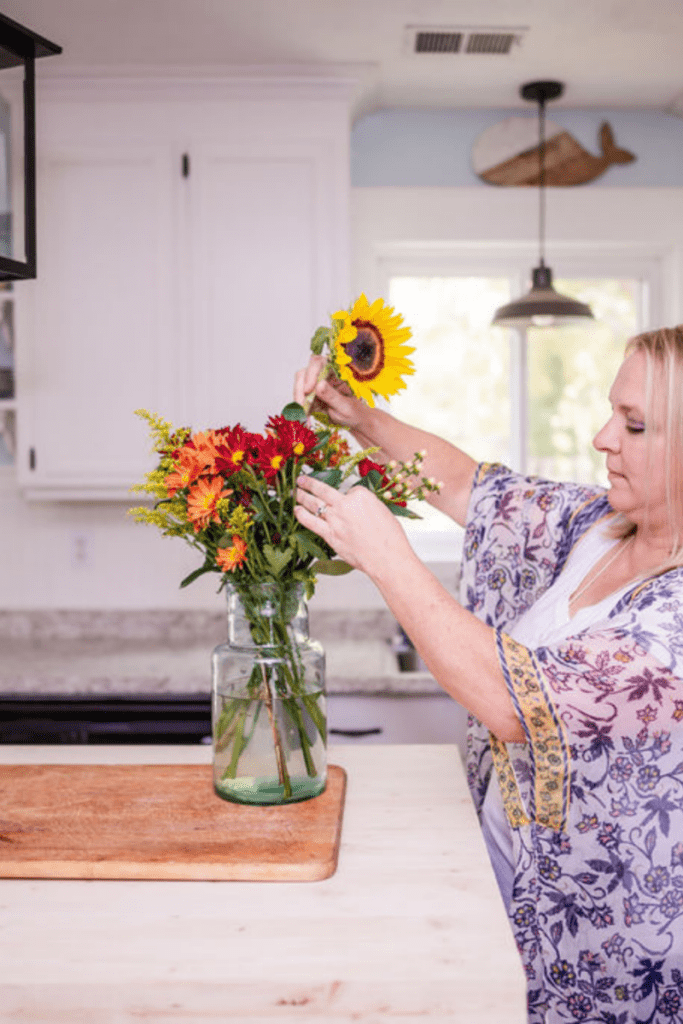 woman arranging flowers in vase