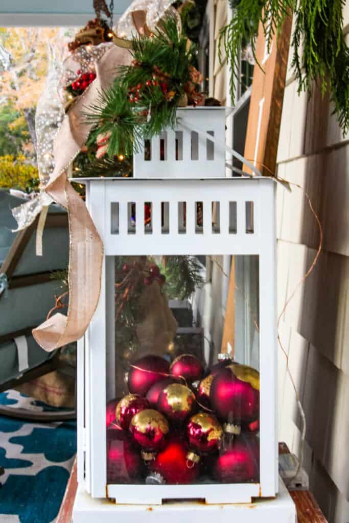 white lantern with red Christmas ornaments