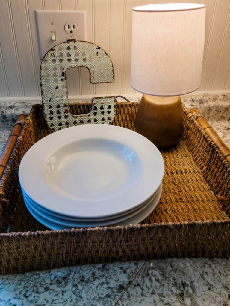 dishes and lamp in basket on countertop