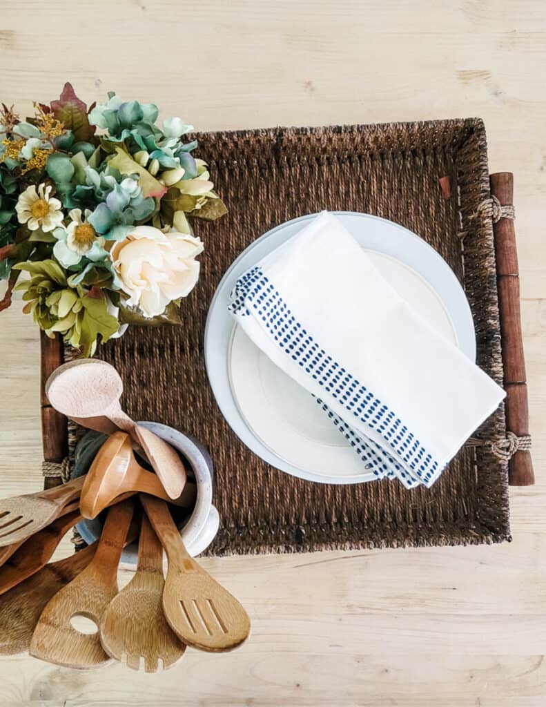 wooden utensils and napkins in basket on kitchen island